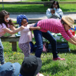 Children doing "tug-of-war" to pull up pretend carrot.